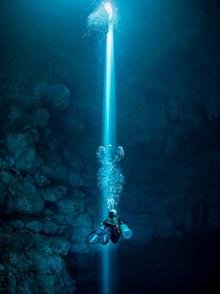 Cave diver Jill Heinerth follows a narrow beam of light towards the surface of an underwater cave in Mexico's Yucatán region.