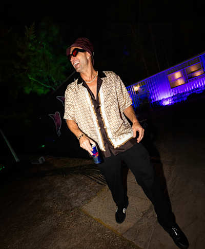 Bucket hat, patterned shirt and after-dark shades are Fisher’s  trademark