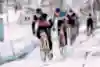 Cyclists racing cyclo-cross in the snow.
