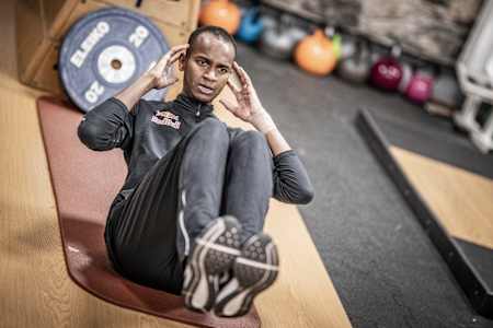 Red Bull athlete doing straight crunches during his workout.