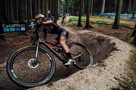 Kate Courtney roule dans un virage de la piste de la Coupe du monde UCI de VTT cross-country 2020 à Nove Mesto na Morave en République Tchèque.