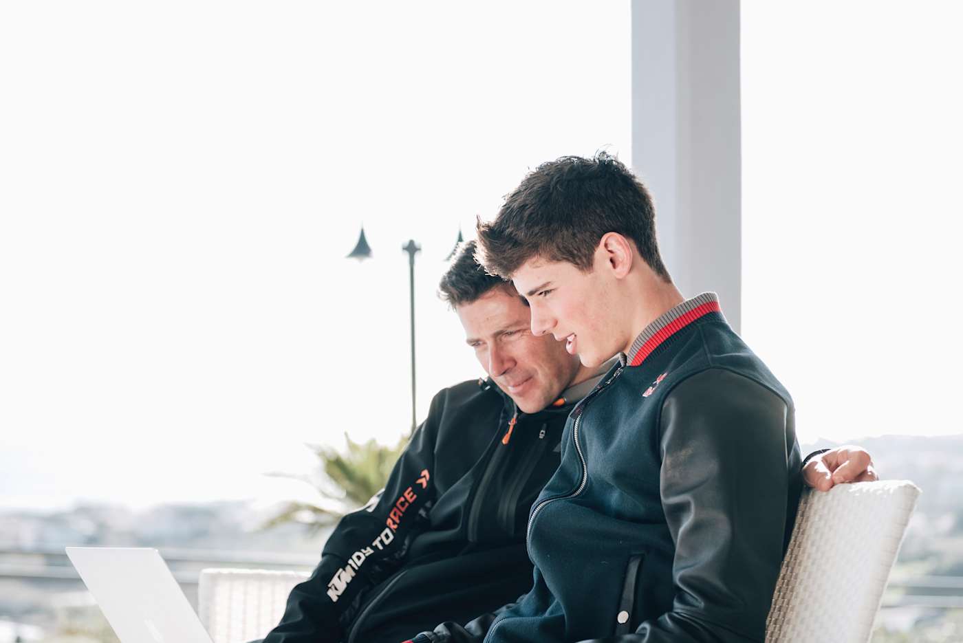 An image of MX rider Jorge Prado and his father looking at a laptop screen.
