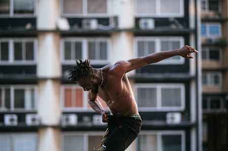 Blayke dancing in front of a blurred building.
