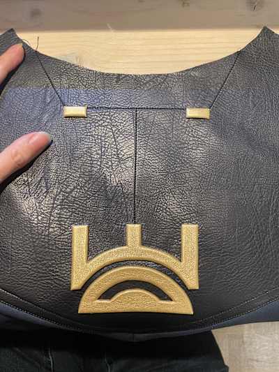 Nahtlose Gold-Embleme und Details aus Moosgummi und goldenem Lederimitat.
