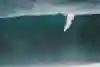 Koa Rothman takes the drop while surfing at Jaws on Maui