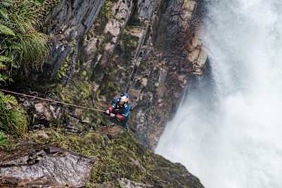 Nouria Newman climbs down towards whitewater in a gorge in Patagonia.