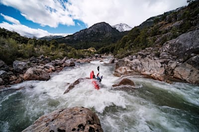 Nouria Newman kayaks towards mountain views in Patagonia.