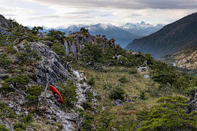 Nouria's team carrying kayaks over steep terrain in Patagonia.