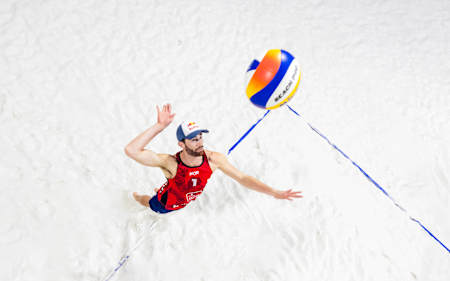 Anders Mol beim Aufschlag im Sand.