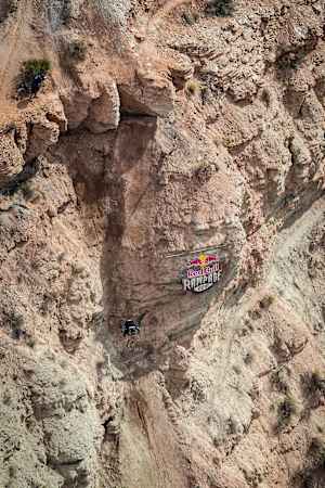 Участник прыгает с гигантского дропа на Red Bull Rampage.