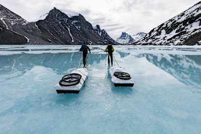 Profi-Kletterer Stefan Glowacz und sein Kletterpartner ziehen Schlitten über einen eisigen Fjord in Kanada.
