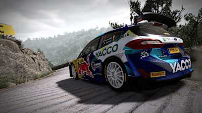A screenshot of a Red Bull vehicle taking a bend in WRC 10