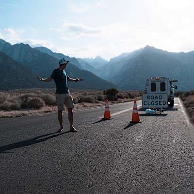 Colin O'Brady stands in front of a 'Road Closed' sign during his record-breaking summiting of the highest point in all 50 states of the USA in 21 days.