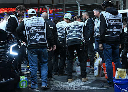 Stewards and course workers try to repair the drain cover in the middle of the F1 Las Vegas Strip Circuit.