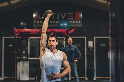 Gee Atherton training with a kettleball at a gym.