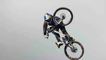 Kade Edwards does a mid-air trick at Dyfi Bike Park while filming for MTB Raw.