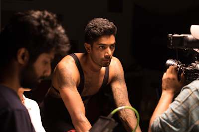 CS Santosh looking focussed while a camera films him on a cycle trainer