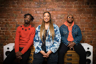 A photo of Tiffany Calver sitting between Nic da Kid and Rasstokyo during filming of Red Bull TV show, The Cut.