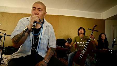 Artist sings with band in background.