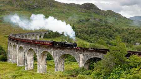 Steam train goes over viaduct in Scotland.