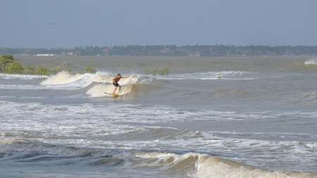 Surfer rides river wave on the Amazon.