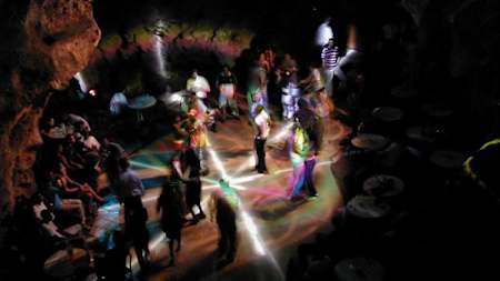 Party goers dance in a cave.