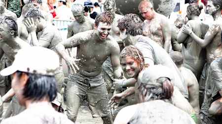 Group of people covered in mud.
