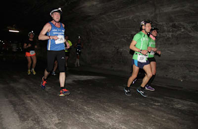 Teilnehmer rennen beim Merkers Kristallmarathon mit Helm und Stirnlampe unter Tage durch das Erlebnisbergwerk.