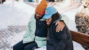 Selema Masekela and snowboarder Zeb Powell sit together on a bench in Aspen, Colorado, during filming of Burton My Turn.