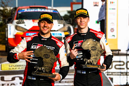 Jonne Halttunen and Kalle Rovanperä celebrate on the podium in first place after winning the World Rally Championship in Naivasha, Kenya on June 26, 2022.