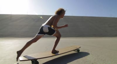 Riding a longboard barefoot.