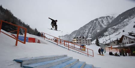Snowboarder springt über ein Rail im Snowpark Kaunertal