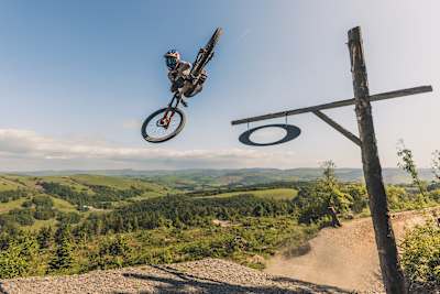 A mountain biker performing a whip at the Red Bull Mountain Bike Performance Camp at Dyfi Bike Park, Wales.
