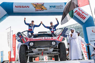 A photo of Jakub Przygonski and his co-driver Timo Gottschalk celebrate reaching the end of the 2019 Abu Dhabi Desert Challenge.