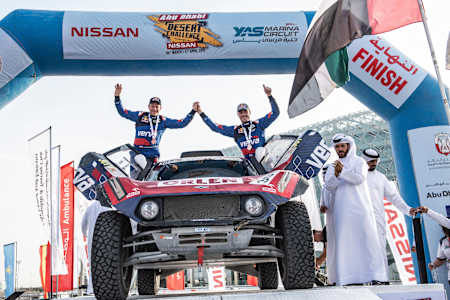 A photo of Jakub Przygonski and his co-driver Timo Gottschalk celebrate reaching the end of the 2019 Abu Dhabi Desert Challenge.