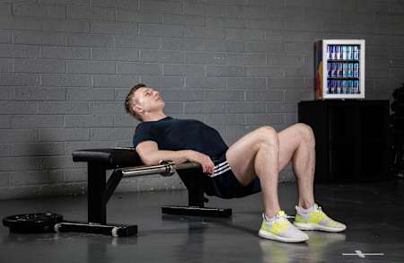 Ijshockeyspeler Joe Canning voert de Glute Bridge oefening uit in een gym.