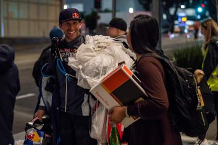 Andy Farrington, of the Red Bull Air Force Team, talks with a passer-by after landing a wingsuit flight through Downtown Los Angeles, CA, USA on 20 March, 2019.