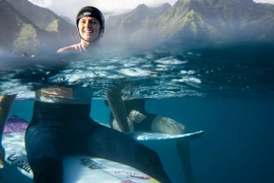 Molly Picklum sitzt auf ihrem Board in Tahiti. 