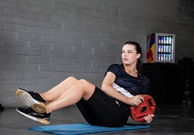 Athlete Ashling Thompson performs a Russian Twist exercise during training.
