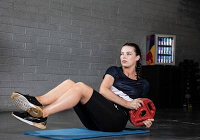 Athlete Ashling Thompson performs a Russian Twist exercise during training.