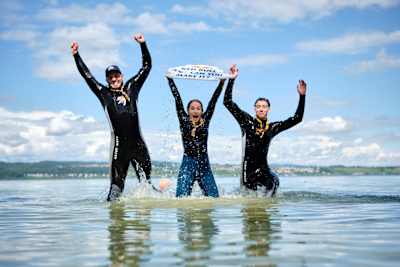 A team jumps out of the water in celebration after completing their challenge at the Red Bull Can You Make It? checkpoint in Constance, Germany.