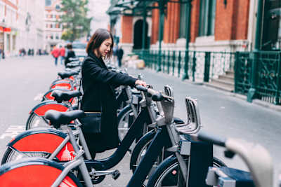 Young woman renting bicycle on street in London