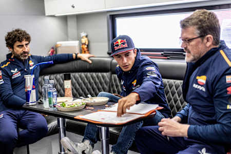 Marc Márquez talks in his trailer with Repsol Honda Team Chief Engineer Santi Hernandez and Electronics Engineer Carlo Luzzi during the MotoGP at Le Mans, France on May 14, 2023.