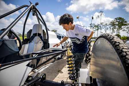 Yuki Tsunoda inspects his swamp buggy prior to his practice lap