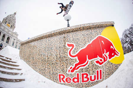 Snowboarder Austin Vizz hits a jump during Red Bull Heavy Metal in 2025, set against the historic backdrop of Saint Paul's Capitol in Minnesota, USA.
