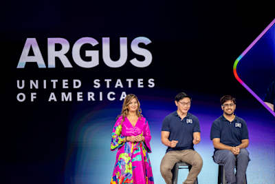 Daniel Kim y Arjun Oberoi, ganadores de la Red Bull Basement US National, presentan su idea Argus en la final de la Microsoft Imagine Cup 2025 junto a la anfitriona Dona Sarkar de Microsoft.