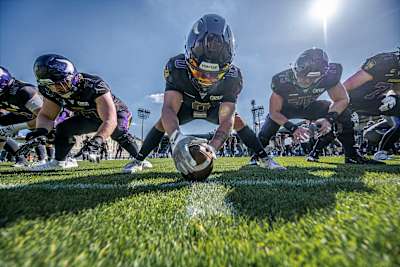 Fünf Spieler der Vienna Vikings kauern in einer Angriffsreihe, einer hält den Ball.