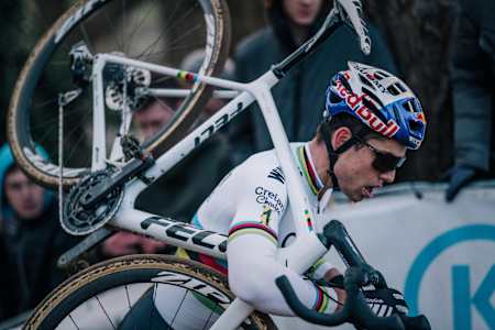 Wout van Aert carga con su bici durante una carrera de ciclocross.