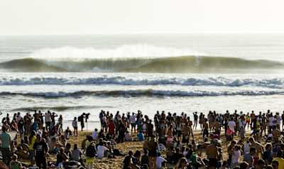 Spectators and photographers marvel at a set of waves at Portugal's surf spot Supertubos. 