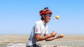 Ed Pratt rides his unicycle and juggles apples